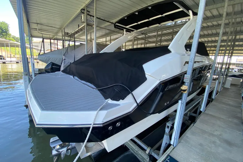 Slide: The Image of 2014 Cruisers 328 Black Diamond boat docked under a covered marina. - 12