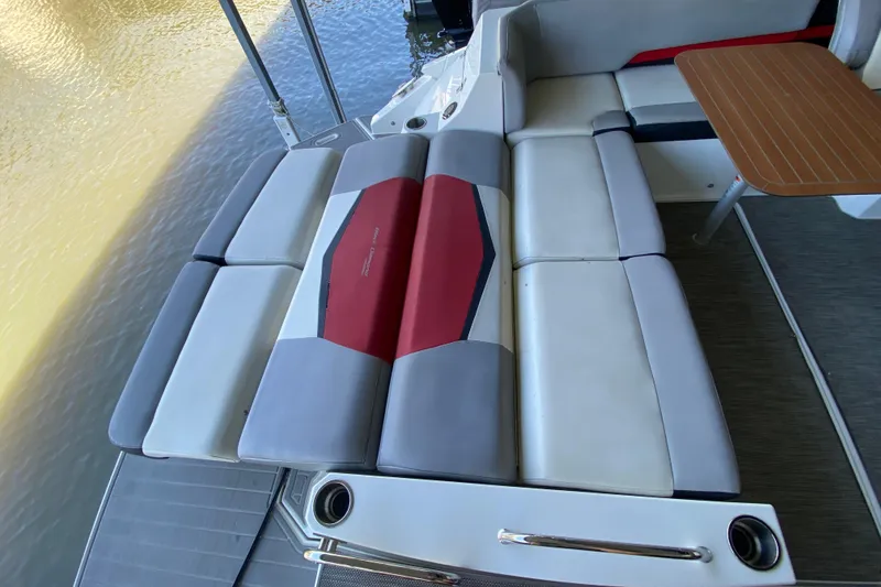 Slide: The Image of 2014 Cruisers 328 Black Diamond boat interior with cushioned seating and wooden table. - 14