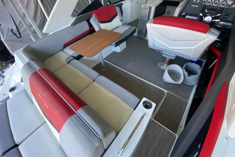 Slide: The Image of 2014 Cruisers 328 Black Diamond boat interior with red and gray seating, wooden table, and helm. - 16