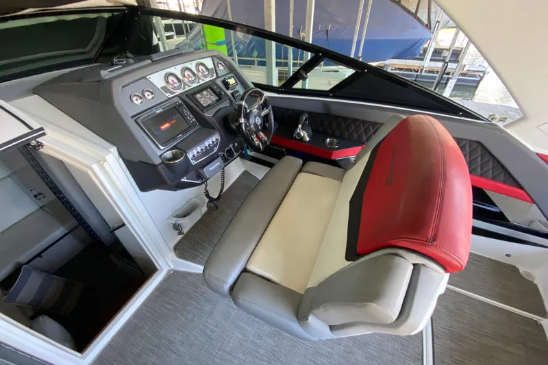 Slide: The Image of 2014 Cruisers 328 Black Diamond helm with modern controls and red-accented seating. - 19