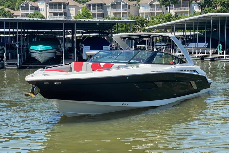 Slide: The Image of 2014 Cruisers Sport Series 328 Black Diamond boat docked in marina. - 2