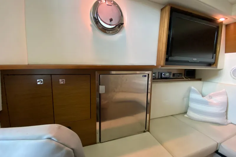 Slide: The Image of Interior of 2014 Cruisers 328 Black Diamond yacht with TV, fridge, and seating area. - 32