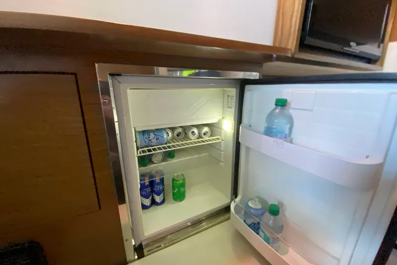Slide: The Image of Mini fridge stocked with drinks inside a 2014 Cruisers 328 Black Diamond boat. - 33