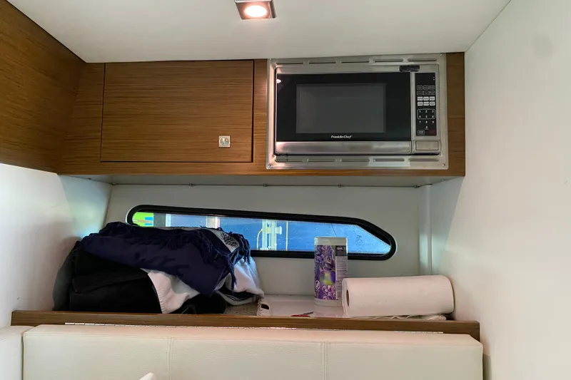 Slide: The Image of Interior of 2014 Cruisers 328 Black Diamond with microwave and storage area. - 36