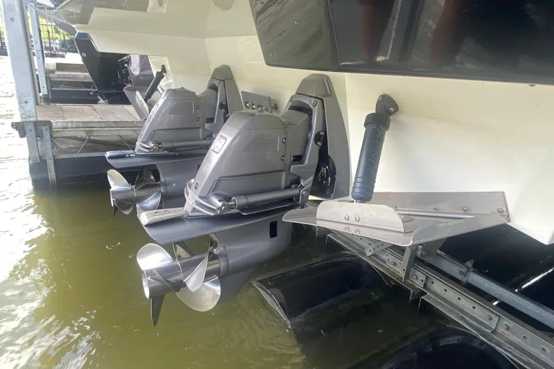 Slide: The Image of 2014 Cruisers 328 Black Diamond boat stern with dual propellers and trim tabs in water. - 52