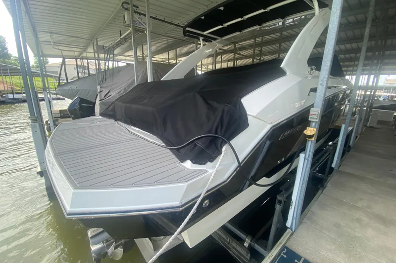 Slide: The Image of 2014 Cruisers Sport Series 328 Black Diamond boat docked under cover. - 57