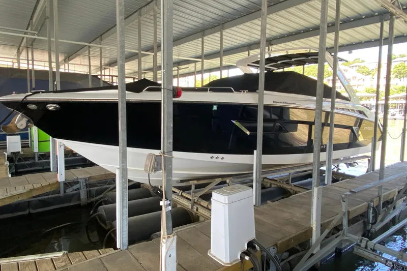 Slide: The Image of 2014 Cruisers 328 Black Diamond boat docked in a covered marina. - 9