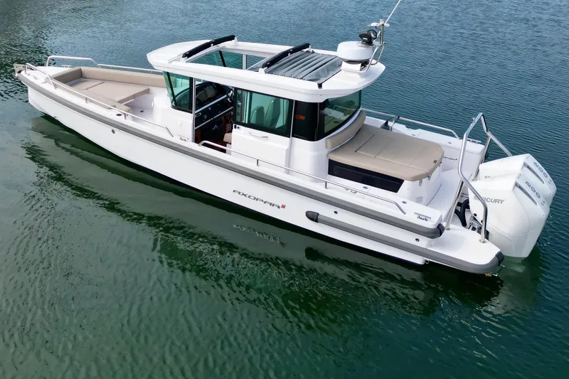 Slide: The Image of 2023 Axopar 28 Cabin boat on calm water, showcasing sleek design and modern features. - 3