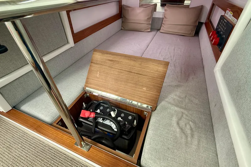 Slide: The Image of 2023 Axopar 28 Cabin interior with storage compartment and battery. - 40