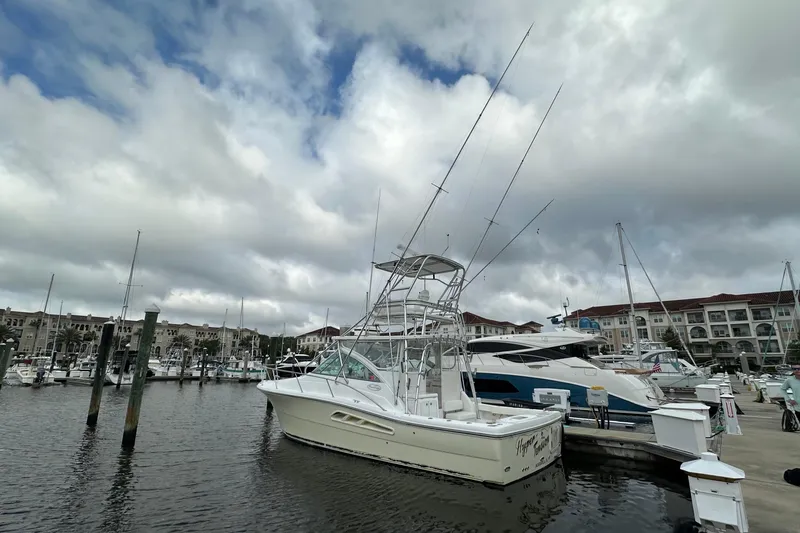 The Image of 2006 Rampage 33 Express boat docked at a marina under cloudy skies. - 0