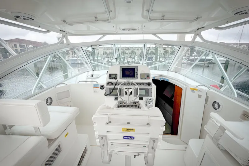 Slide: The Image of 2006 Rampage 33 Express boat cockpit with modern controls and marina view. - 4