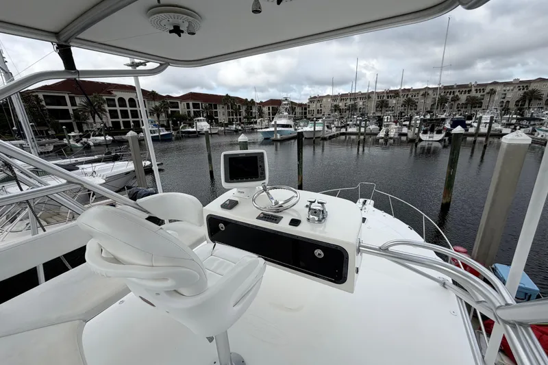 Slide: The Image of Helm of 2006 Rampage 33 Express yacht in marina, featuring steering wheel and navigation equipment. - 5