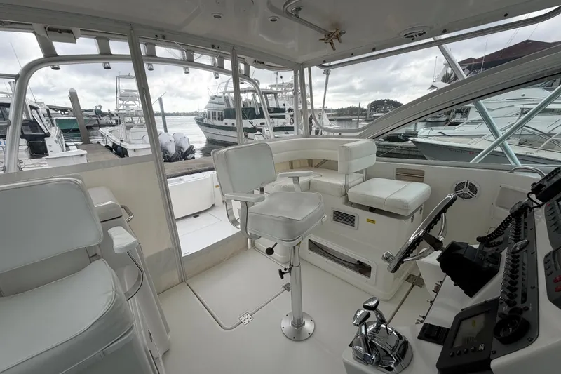 Slide: The Image of 2006 Rampage 33 Express boat interior with helm, seating, and marina view. - 6