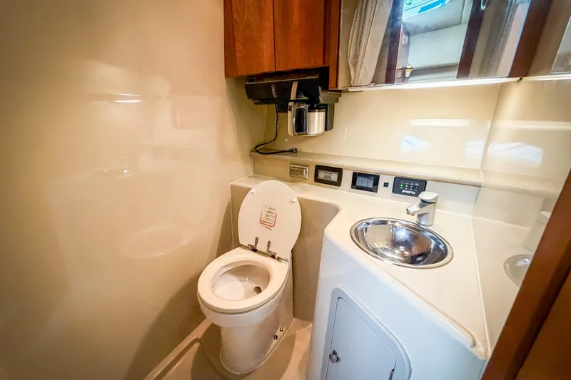 Slide: The Image of Compact bathroom in a 2006 Rampage 33 Express yacht, featuring a toilet and sink. - 9