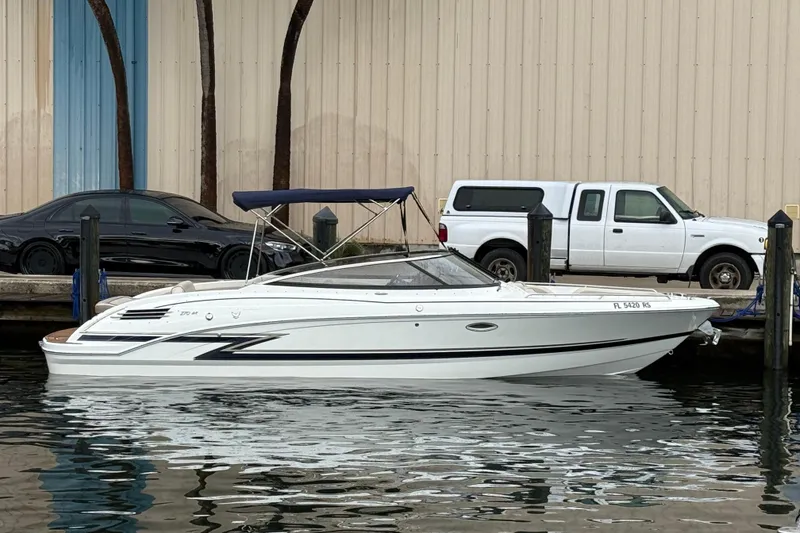 Slide: The Image of 2019 Formula 270 Bowrider boat docked beside vehicles, featuring sleek design and canopy. - 10