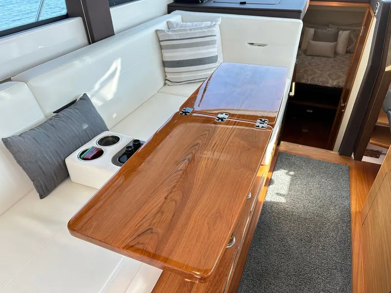 Slide: The Image of Interior of 2019 Tiara Yachts Coupe 39 with wooden table and cushions. - 27