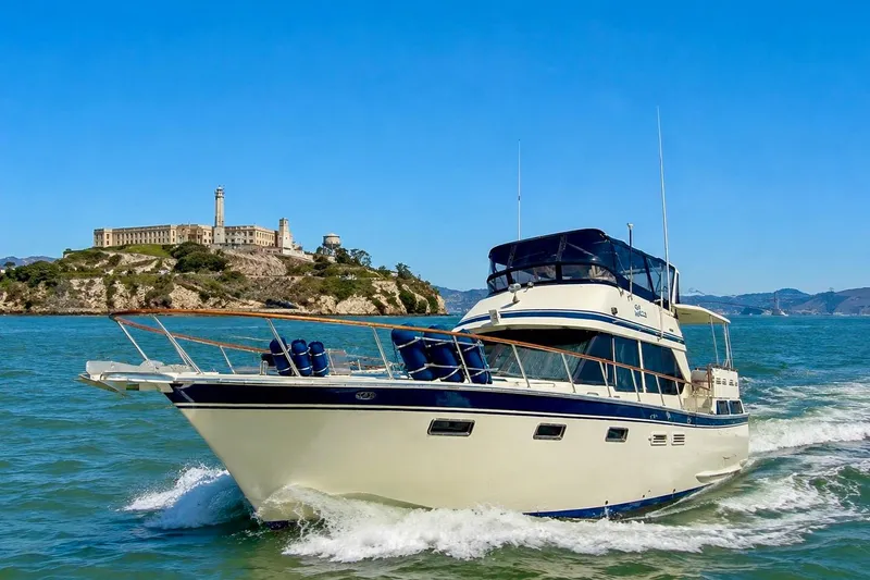 Slide: The Image of 1987 PT Sundeck yacht cruising near historic island under clear blue sky. - 1