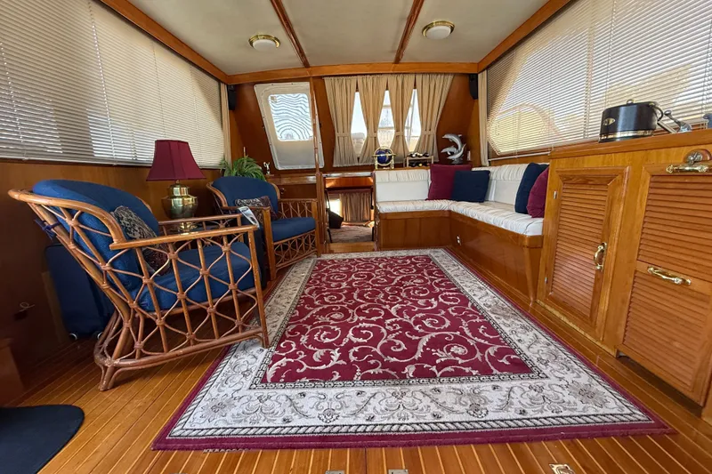 Slide: The Image of Luxurious 1987 PT Sundeck yacht interior with elegant seating, wooden accents, and decorative rug. - 11