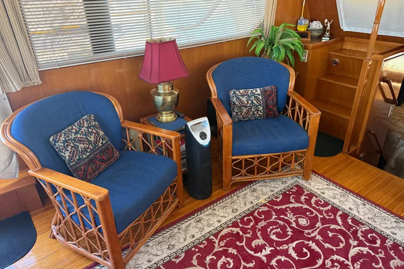Slide: The Image of Cozy 1987 PT Sundeck interior with wicker chairs, decorative pillows, and a red patterned rug. - 12
