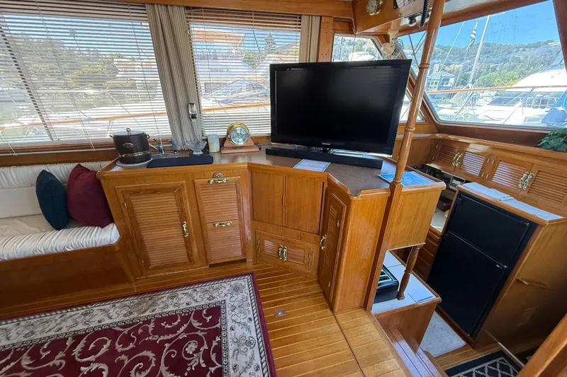 Slide: The Image of Luxurious 1987 PT Sundeck yacht interior with wood cabinetry, TV, and seating area. - 15