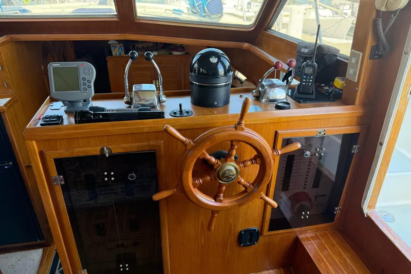 Slide: The Image of 1987 PT Sundeck helm with wooden wheel, navigation instruments, and control panel. - 17