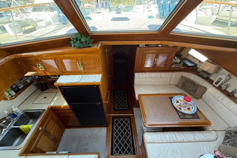 Slide: The Image of 1987 PT Sundeck yacht interior with kitchen, dining area, and wooden cabinetry. - 18
