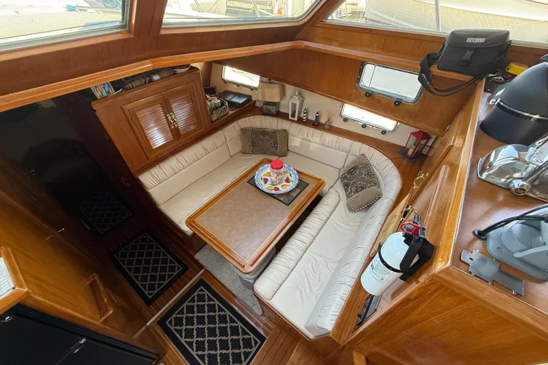 Slide: The Image of 1987 PT Sundeck yacht interior with cozy seating, wooden finishes, and nautical decor. - 19