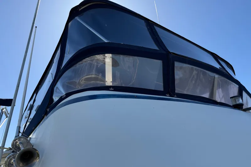 Slide: The Image of 1987 PT Sundeck boat with blue canopy against clear sky. - 2