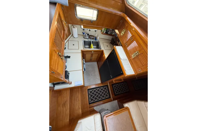 Slide: The Image of 1987 PT Sundeck yacht interior kitchen with wooden cabinetry and modern appliances. - 20