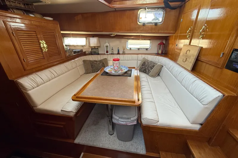 Slide: The Image of Cozy 1987 PT Sundeck yacht interior with wooden cabinetry and cushioned seating area. - 22