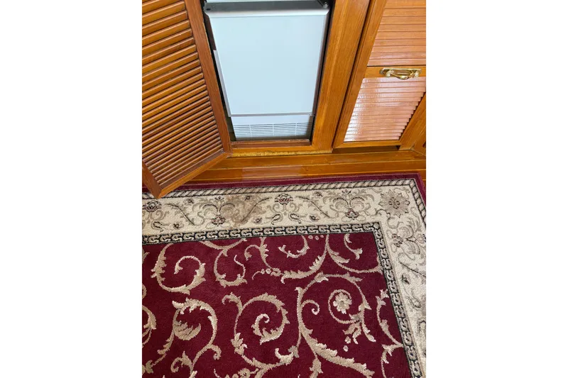Slide: The Image of Wooden cabinet with open door, ornate red and beige carpet, PT Sundeck 1987 interior. - 24