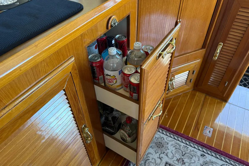 Slide: The Image of Wooden cabinet on 1987 PT Sundeck yacht, storing assorted beverages and drinks. - 25