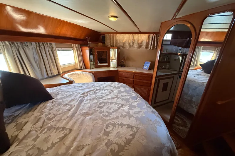 Slide: The Image of Cozy bedroom interior of 1987 PT Sundeck yacht with wood accents and elegant bedding. - 29