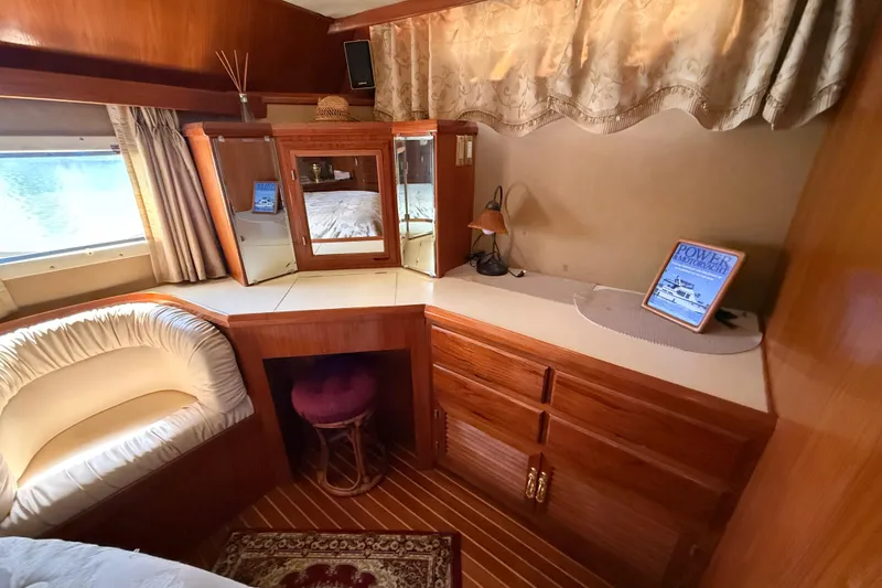 Slide: The Image of 1987 PT Sundeck yacht interior with wooden cabinetry, cozy seating, and decorative elements. - 32