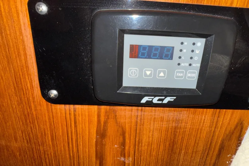 Slide: The Image of Control panel on 1987 PT Sundeck boat, featuring FCF display and wooden background. - 33