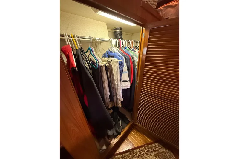 Slide: The Image of Closet inside 1987 PT Sundeck boat with hanging clothes and wooden door. - 34