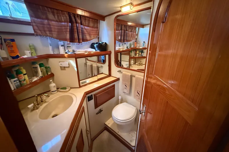 Slide: The Image of 1987 PT Sundeck yacht bathroom with wooden cabinetry, sink, and toilet. - 35