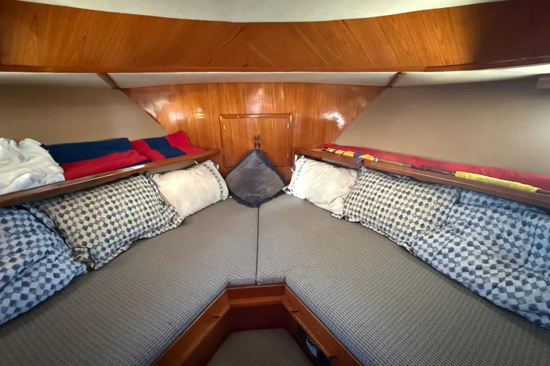Slide: The Image of Cozy cabin interior of 1987 PT Sundeck boat with patterned pillows and wooden paneling. - 37
