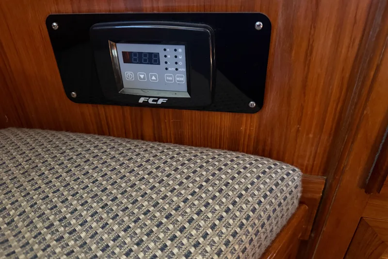 Slide: The Image of Control panel on 1987 PT Sundeck boat with patterned upholstery and wooden interior. - 38