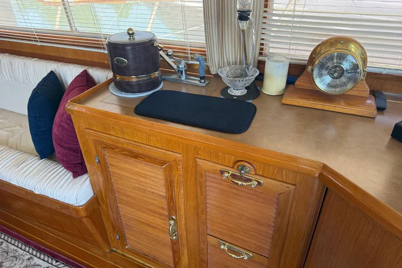 Slide: The Image of 1987 PT Sundeck interior with wooden cabinetry, nautical decor, and comfortable seating. - 44
