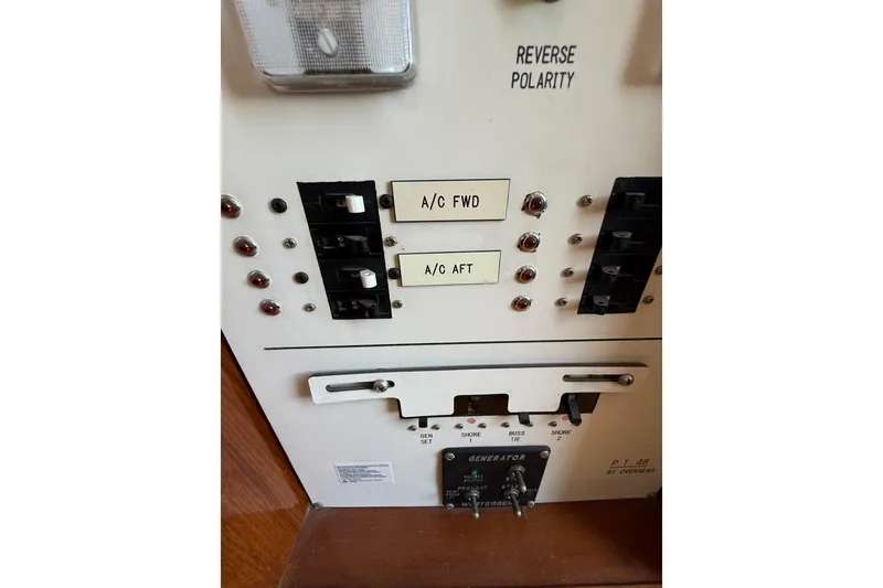 Slide: The Image of Control panel of a 1987 PT Sundeck boat with A/C and generator switches. - 46