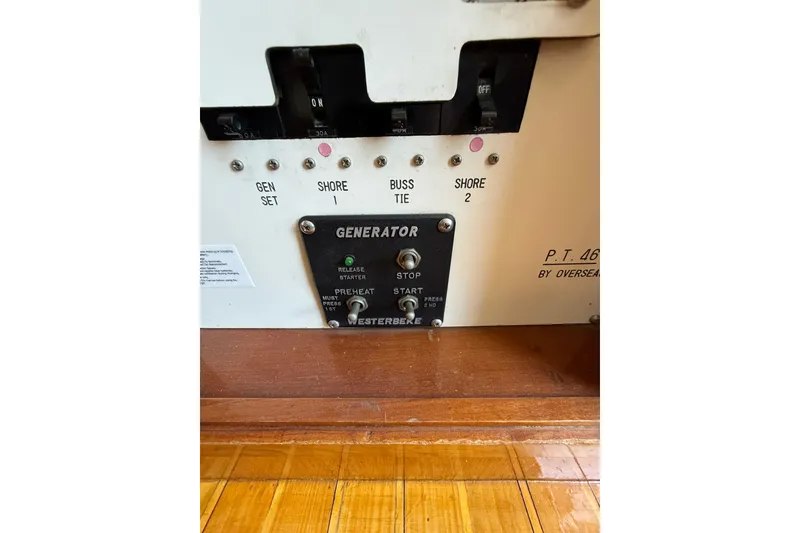 Slide: The Image of Control panel of a 1987 PT Sundeck boat with generator switches and labels. - 47