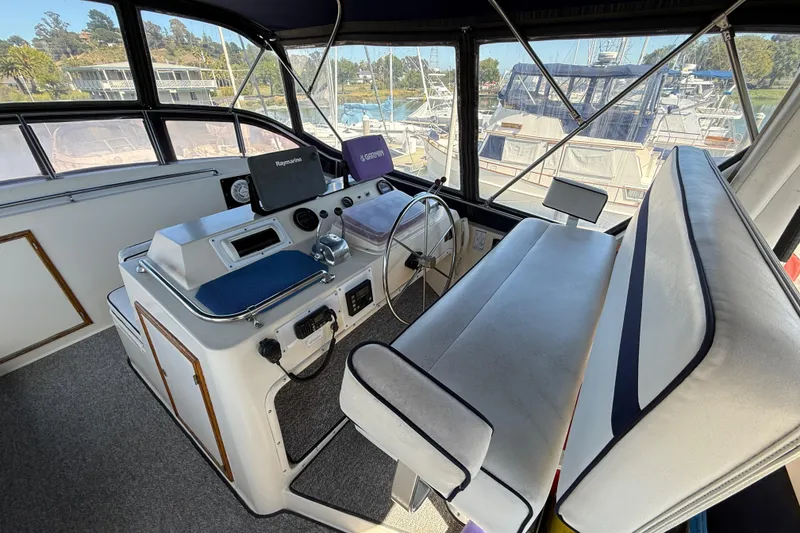 Slide: The Image of Interior of a 1987 PT Sundeck boat with steering console and seating. - 5