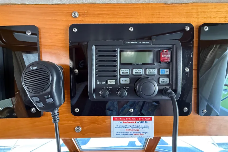 Slide: The Image of VHF marine radio on 1987 PT Sundeck boat dashboard with microphone and distress button. - 53