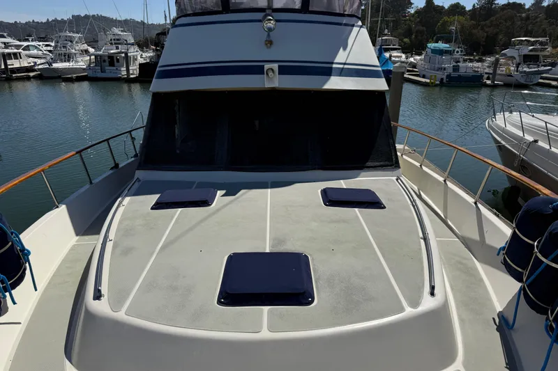 Slide: The Image of 1987 PT Sundeck yacht docked at marina, featuring spacious deck and sleek design. - 59