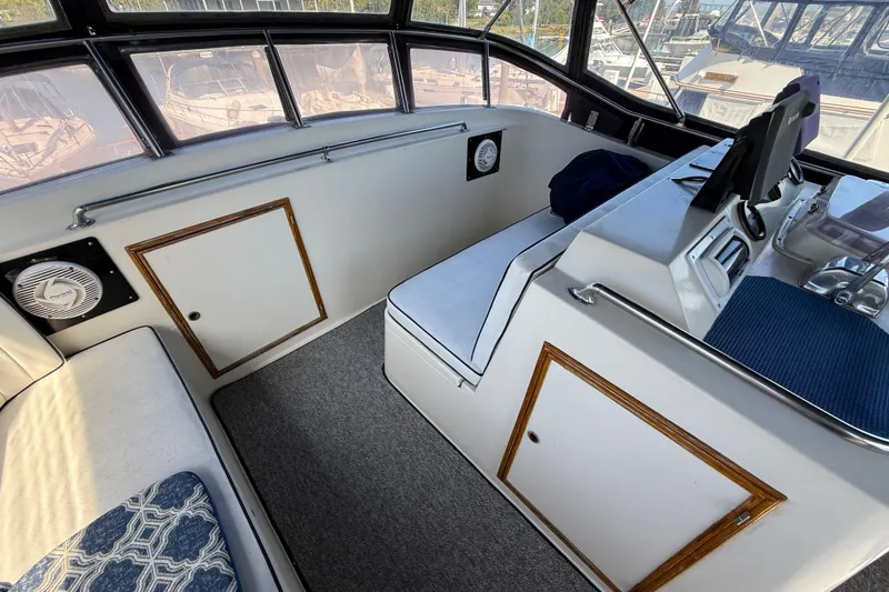 Slide: The Image of 1987 PT Sundeck boat interior with seating, control panel, and windows overlooking marina. - 6