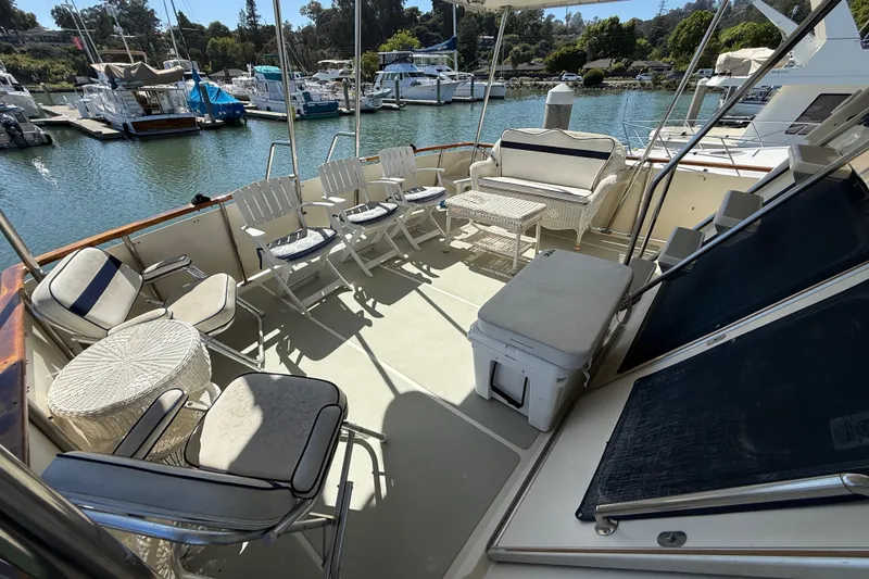 Slide: The Image of 1987 PT Sundeck boat with spacious deck, seating, and marina view. - 60