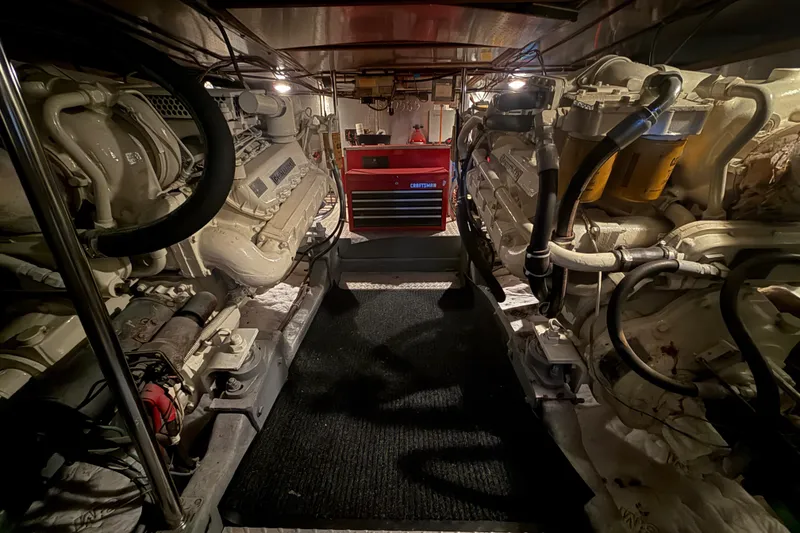 Slide: The Image of Engine room of a 1987 PT Sundeck yacht with dual engines and tool chest. - 61