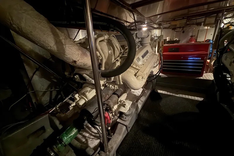 Slide: The Image of Engine room of a 1987 PT Sundeck yacht with visible machinery and tool chest. - 63