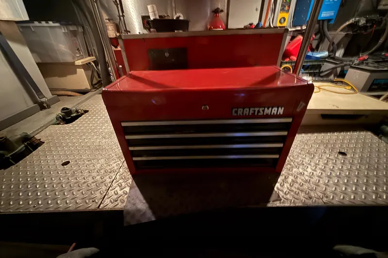 Slide: The Image of Red Craftsman toolbox on a metal platform inside a 1987 PT Sundeck boat. - 64
